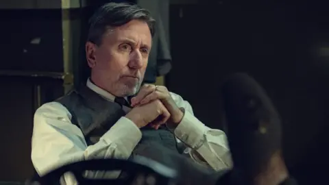 In Peaky Blinders: The Immortal Man, Tim Roth's character attempts to introduce forged currency into the British economy