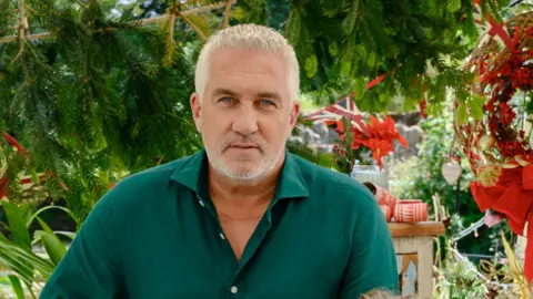 PA Media Image shows celebrity baker Paul Hollywood, in a green shirt, standing on the set of the Great British Bake-Off