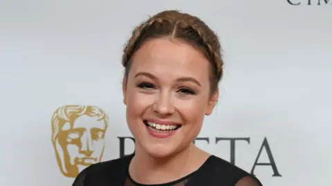 Getty Images Actress Kimberley Nixon with her hair plaited and tied back smiling