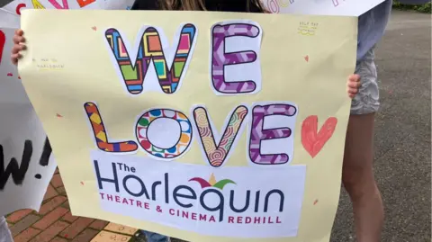 A protest sign which says "we love the Harlequin Theatre and Cinema Redhill."