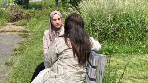 Haleema and Maryam, not her real name, sat on a bench in a park.
