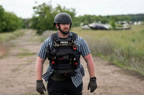 Reuters Reuters safety advisor Ryan Evans stands in a field while working with a news reporting team in an undated photo taken in Ukraine