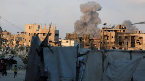 Reuters rises smoke over the parties that are partially created and other buildings that are burned and damaged, after an Israeli strike in Gaza City (August 21, 2025)