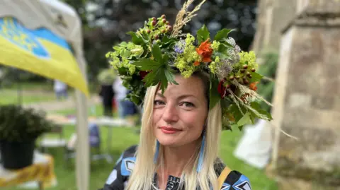 Olena Spasibo with long blonde hair wearing a flower crown she made.