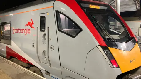 A Greater Anglia train stopped at a train platform.