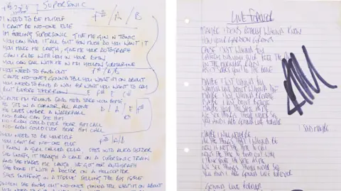 PA Media Two sheets of paper side-by-side with handwritten Oasis lyrics for Supersonic and Live Forever