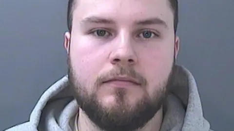 Police mugshot of Lewis Edwards wearing a grey hoodie