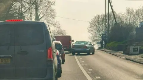 John Withers A car pulling out of a queue of stationary traffic.