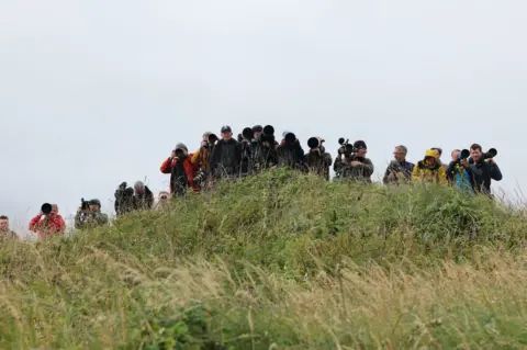 Reuters Journalists and photographers on a grassy hill at Turnberry