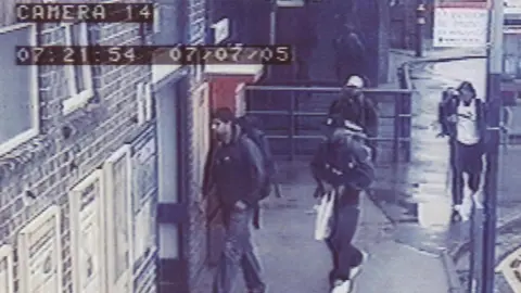 Metropolitan Police via PA A grainy CCTV image of four men dressed mainly in dark clothing walking towards a door entrance. Two of the men are wearing caps and some can be seen carrying backpacks.