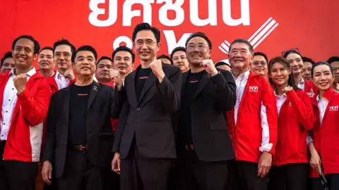 AFP via Getty Images Pheu Thai Party's prime ministerial candidate Yodchanan Wongsawat (C) poses with fellow party members during a campaign rally ahead of the general election at Thephasadin Stadium in Bangkok on February 6, 2026