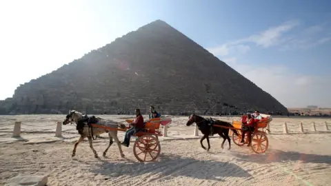 EPA Image shows tourists in front of the Giza pyramids in Egypt