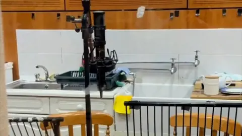 A kitchen sink inside a radio studio, with a microphone in the foreground