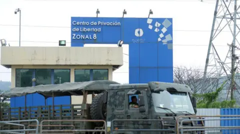 General view of the Penitentiary of Litoral on January 18, 2024 in Guayaquil, Ecuador. A military lorry is parked in front of a guard post behind which a wall painted blue can be seen. 