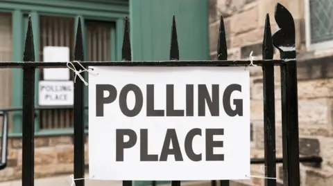 AFP via Getty Images Polling place sign attached to a metal gate