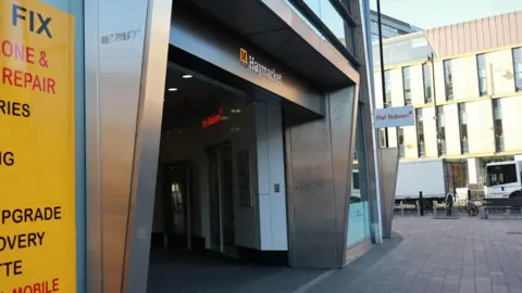 The entrance of Haymarket Metro on Northumberland Street in Newcastle - it is a metal doorway with the Metro logo and the word Haymarket running along the top