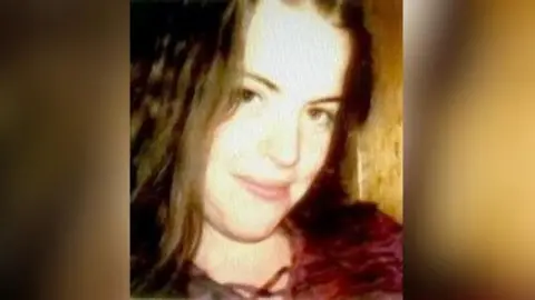 An Garda Síochána A photo of Fiona Sinnott taken around the time of her disappearance in 1998. The 19-year-old had shoulder-length auburn hair and brown eyes and in the photo she is wearing a dark red top laced up at the neck.