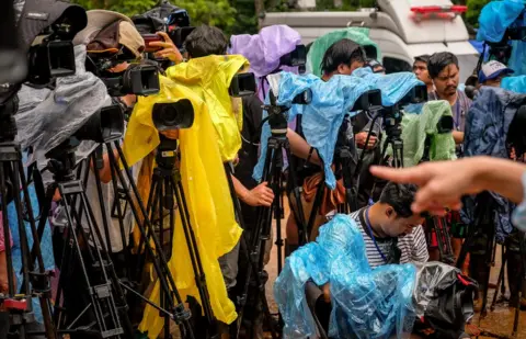 Getty Images The press waits for an official announcement at Khun Nam Nang Non Forest Park on 30 June