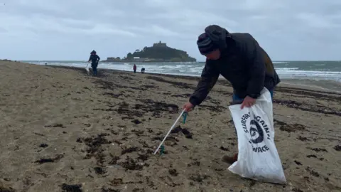 Beach cleaner picking up litter