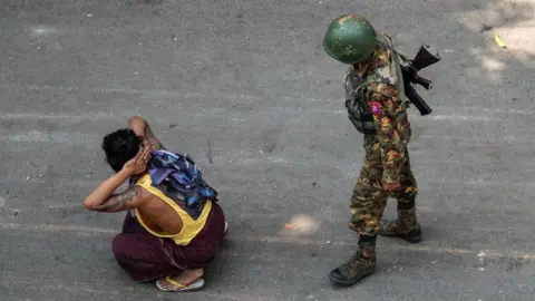 Getty Images Myanmar soldier with arrested civilian