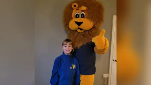 Cambridgeshire Community Services Doctor dressed as a lion standing with his daughter