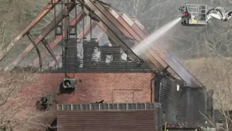 Water being sprayed on a building ravaged by fire 