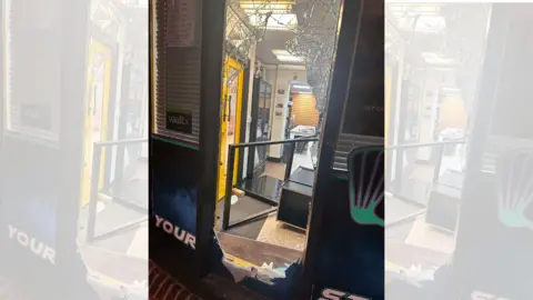 Supplied A smashed front door of a shop.