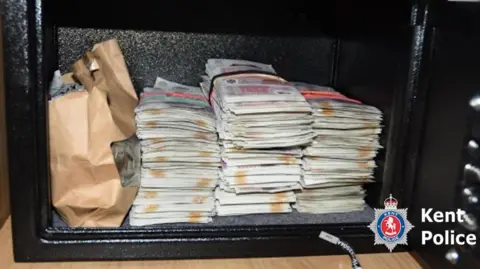 Kent Police A metal safe containing wads of cash.
