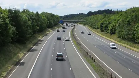 The A74(M) motorway in the south of Scotland with a number of cars and lorries travelling along it