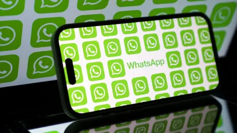 A smart phone on its side, with its screen displaying the world WhatsApp and multiple WhatsApp logos.