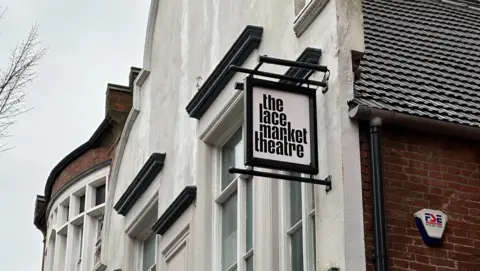 A general view of the Lace Market Theatre, showing only the top of the façade of the building with a sign that reads 'the lace market theatre' in bold black and white front