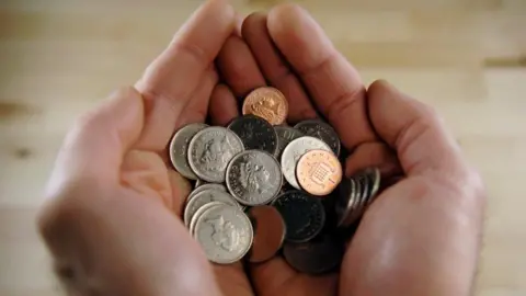 Getty Images Hands with coins