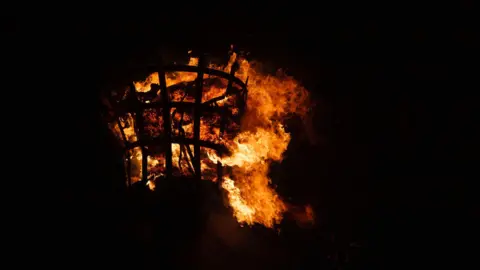 Getty Images A beacon burns at night. 
