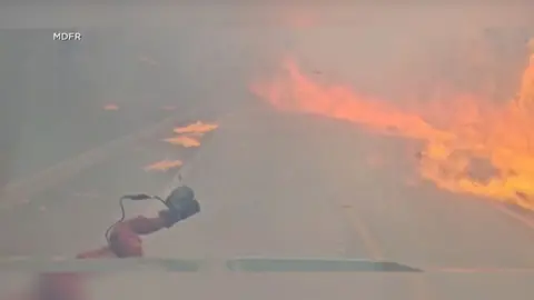 Vehicle is driving through fire on the road in Florida.