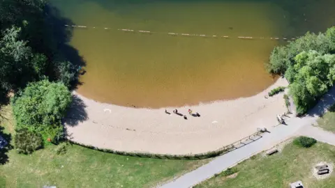 A sandy beach on a lake. 