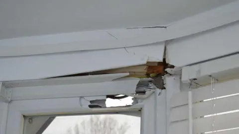 Met Police Damage to a window frame in a house nearby
