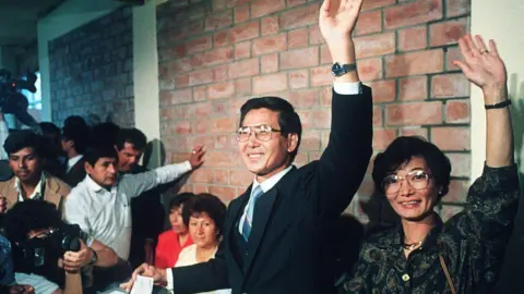 [AFP]Presidential candidate Alberto Kenyo Fujimori "Cambio 90" The party leader and his wife Susana salute in Lima on June 10, 1990.