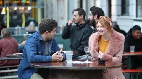 People drinking outside a bar in Manchester