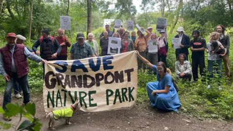 Friends of Grandpont Nature Park Friends of Grandpont Nature Park in a forest with a 'Save Grandpont Nature Park' banner