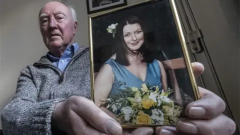 PA Media Peter Lawrence with photo of Claudia