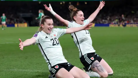 PA Media Wales' Carrie Jones (left) celebrates scoring their side's second goal with team-mate Rachel Rowe during the UEFA Women's Euro 2025 Qualifying play off round two, second leg match at the Aviva Stadium, Dublin in Ireland.