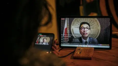 AFP via Getty Images Video of President Andry Rajoelina on an tablet screen