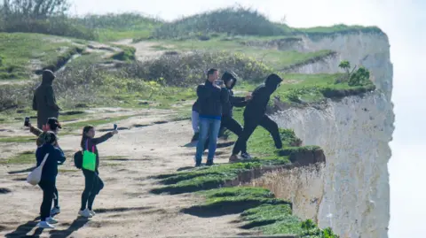 David McHugh People at Birling Gap cliff edge 