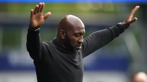 PA Media Darren Moore with his arms aloft