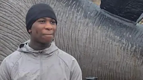 Eghosa Ogbebor in a grey jacket and a black beanie