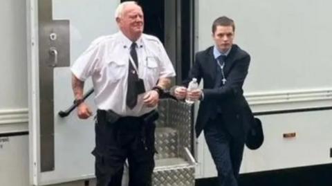 Liam Stimpson being led from custody van