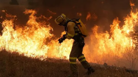 A firefighter battles a large blaze