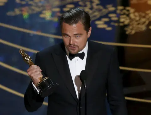Reuters Leonardo DiCaprio, in a tuxedo, holds an Oscar and makes a speech at the Academy Awards in 2016