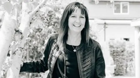 Family A black and white photo of a woman in a black leather jacket smiling