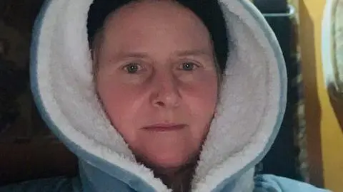 JO DUNNE Jo Dunne with the the hood up on a blue and white fleece top in the camper van.